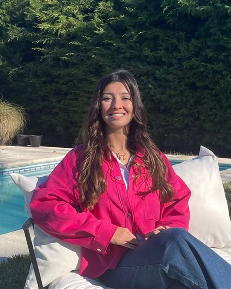 Maria Luján Medone sonriendo, sentada en su jardín